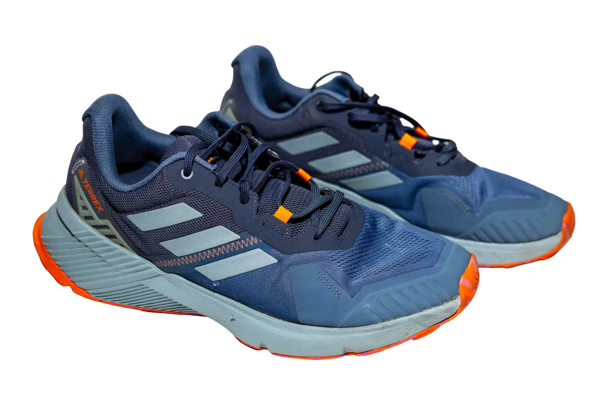 The same Adidas sneakers after cleaning at QuickWash: clean soles and bright colours